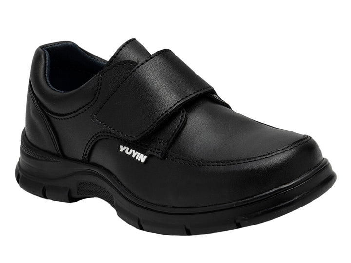 Zapato infantil color negro de material sintético con cierre de correa y suela gruesa.