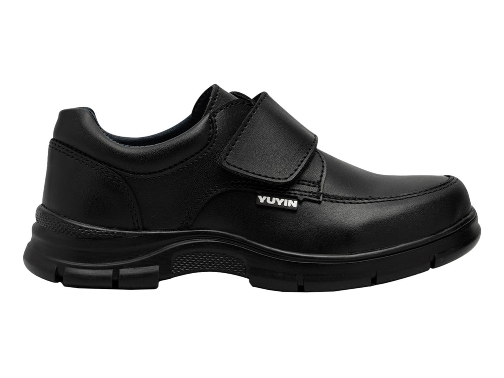 Zapato infantil color negro de material sintético con cierre de correa y suela gruesa.