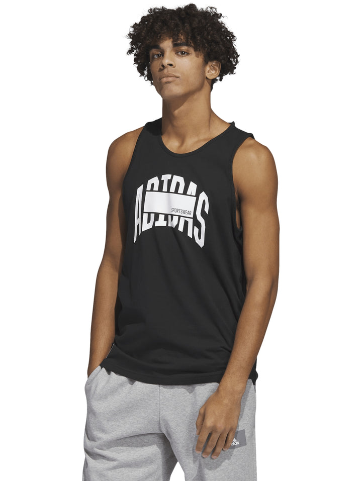Hombre vistiendo una camiseta sin mangas color negro de la marca Adidas con logotipo blanco en el pecho.
