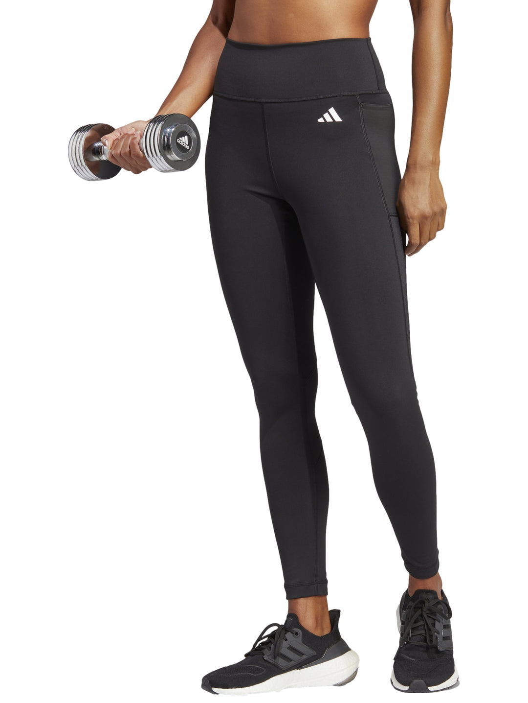 Mujer vistiendo leggings deportivos negros de talle alto marca Adidas.