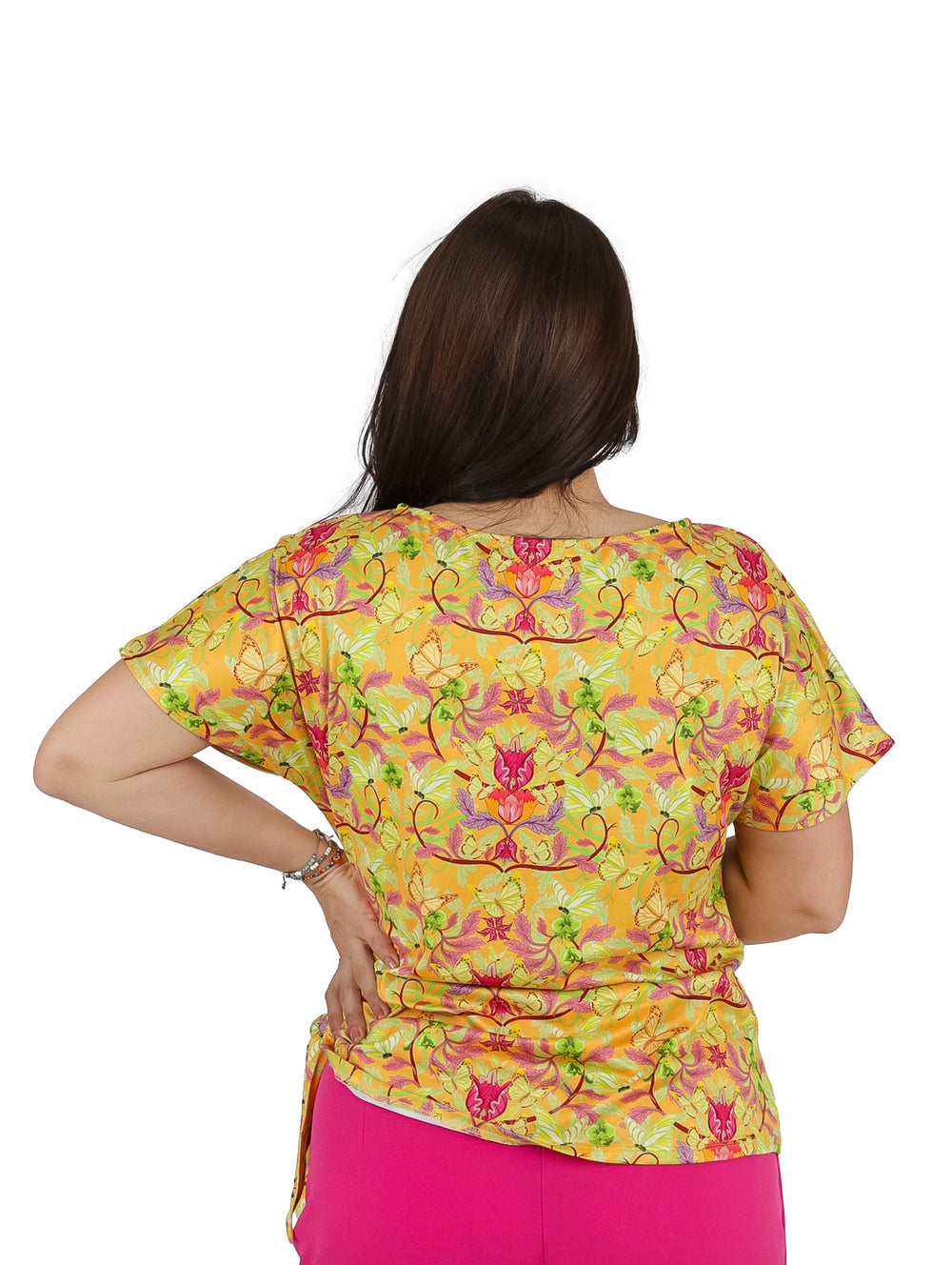 Mujer vistiendo blusa color mostaza con estampado floral de manga corta y detalle de nudo lateral.