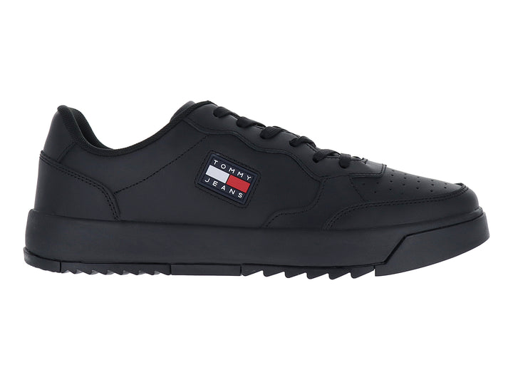 Tenis negros Tommy Jeans de corte bajo con suela gruesa y logo lateral.