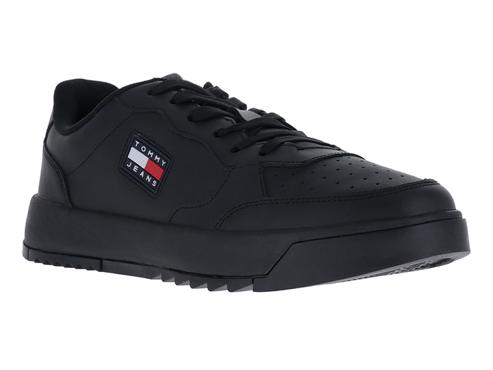 Tenis negros Tommy Jeans de corte bajo con suela gruesa y logo lateral.