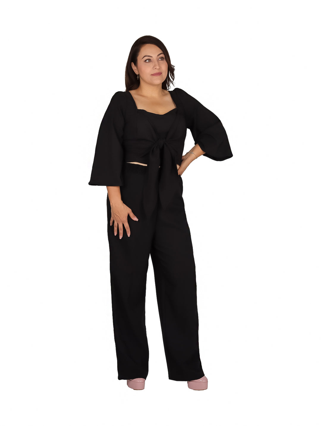 Mujer vistiendo un conjunto negro de dos piezas con pantalón ancho y blusa con nudo frontal.