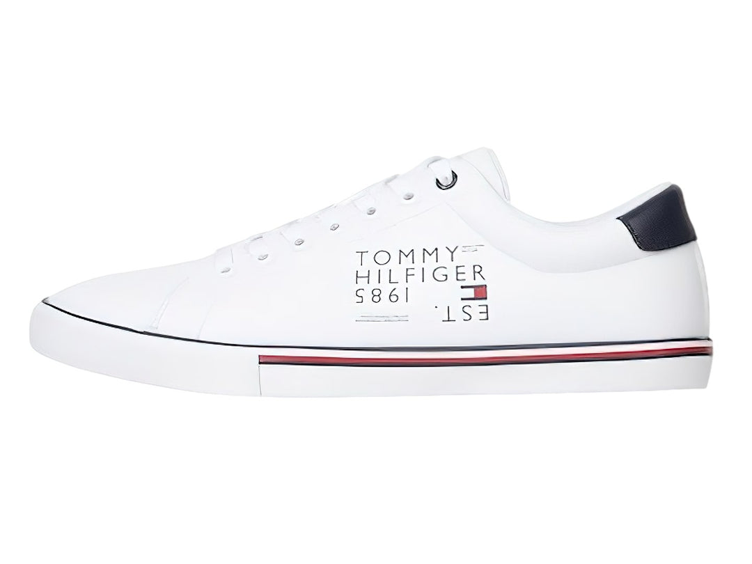 Tenis blancos Tommy Hilfiger con detalles lineales en azul y rojo en la suela y talón en color azul marino.