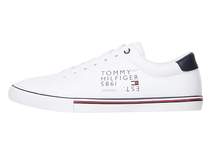 Tenis blancos Tommy Hilfiger con detalles lineales en azul y rojo en la suela y talón en color azul marino.