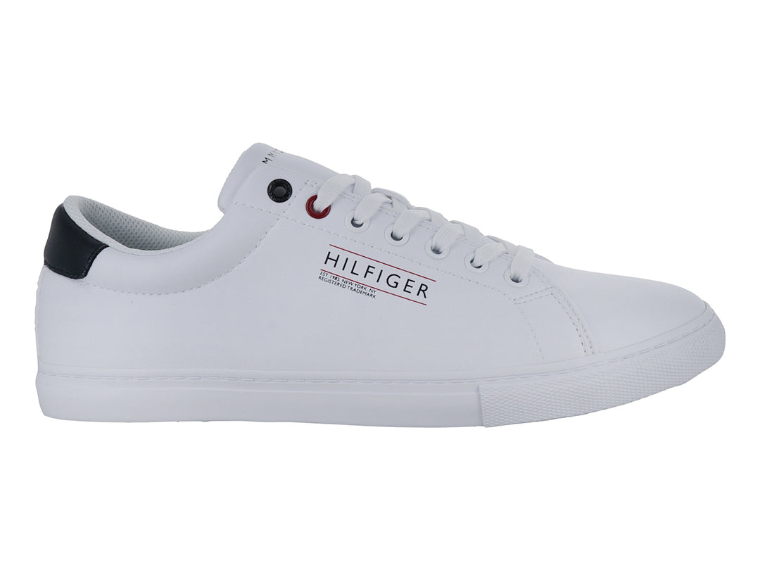Tenis blancos Tommy Hilfiger de corte bajo con suela vulcanizada y detalle azul en el talón.