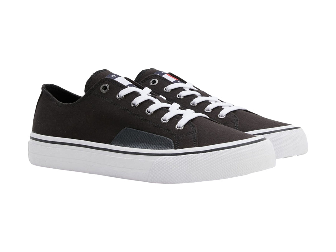 Tenis Tommy Hilfiger de lona color negro con suela y agujetas blancas, estilo skate.