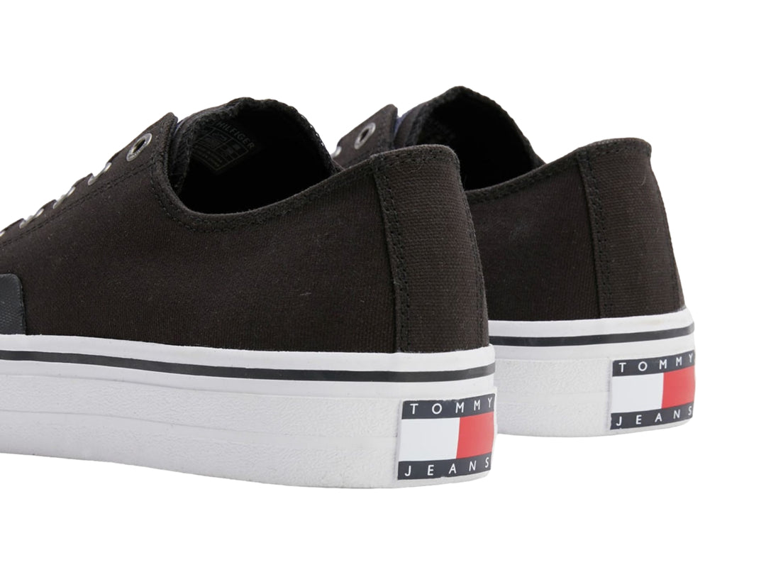 Tenis Tommy Hilfiger de lona color negro con suela y agujetas blancas, estilo skate.