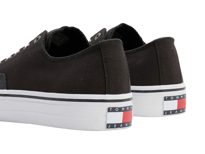 Tenis Tommy Hilfiger de lona color negro con suela y agujetas blancas, estilo skate.