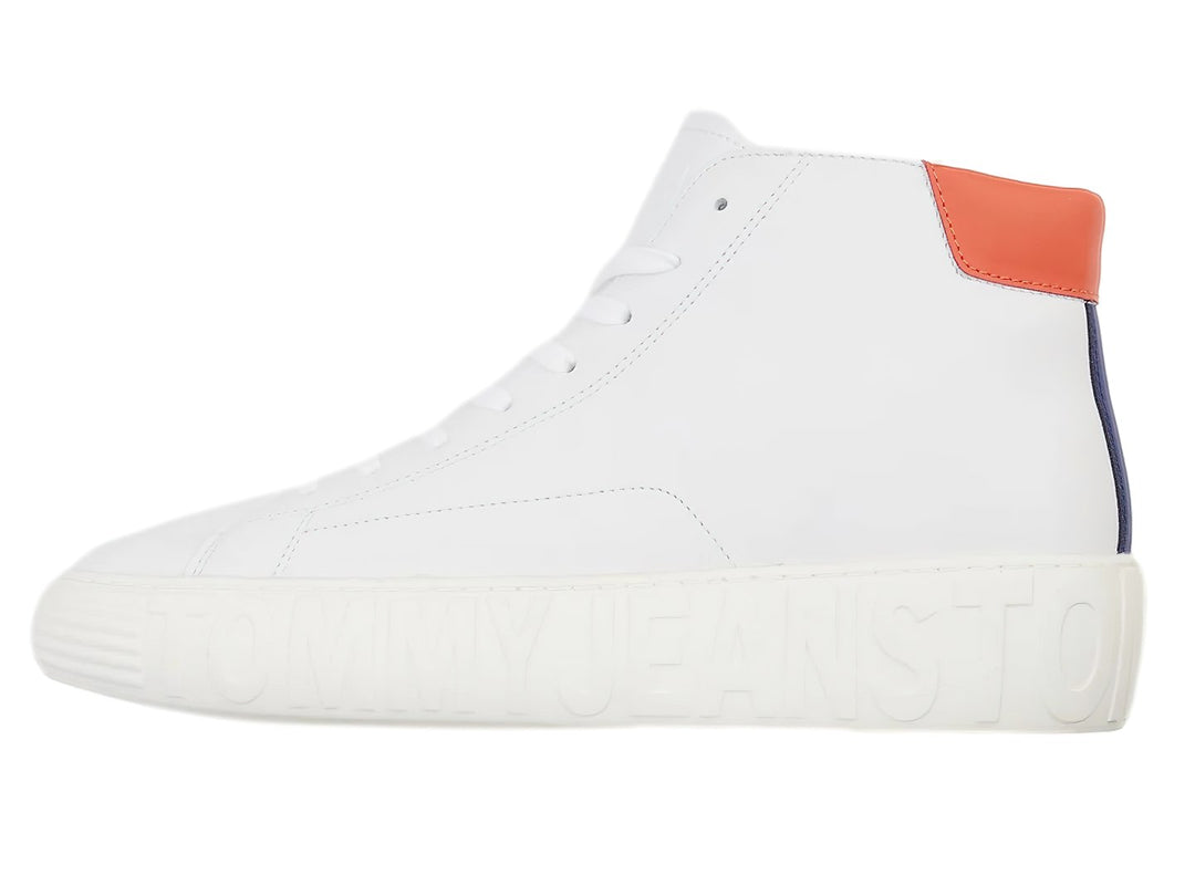 Tenis blancos de corte medio con suela gruesa y detalle rojo en el talón.