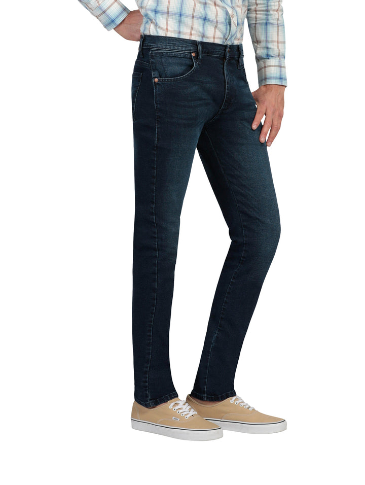 Hombre vistiendo pantalones jeans skinny de color azul oscuro.