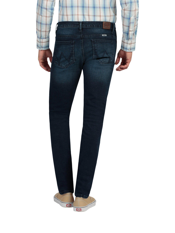 Hombre vistiendo pantalones jeans skinny de color azul oscuro.