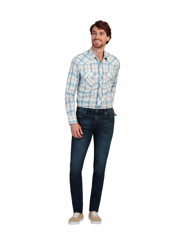 Hombre vistiendo pantalones jeans skinny de color azul oscuro.