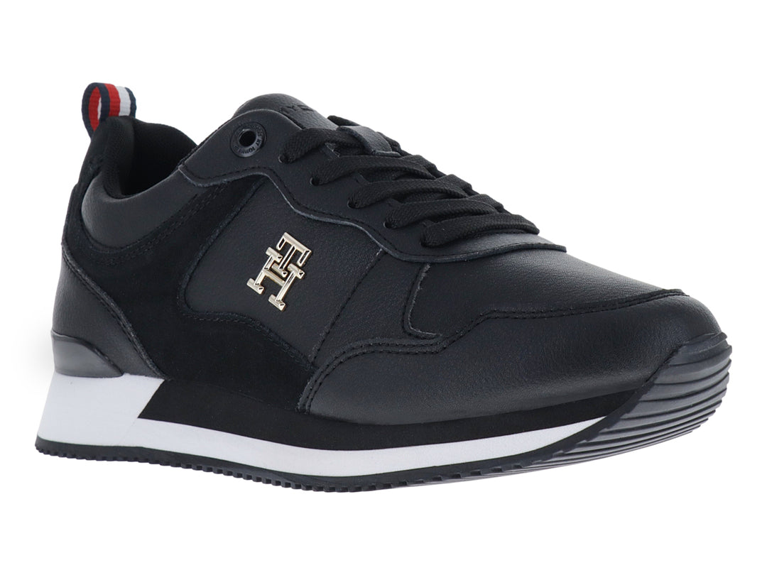 Tenis Tommy Hilfiger modelo Essential Runner en color negro con suela blanca y logo dorado lateral.