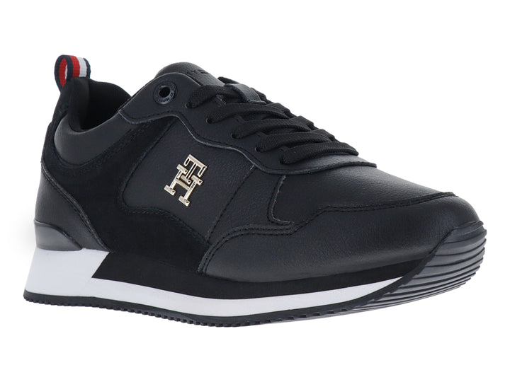 Tenis Tommy Hilfiger modelo Essential Runner en color negro con suela blanca y logo dorado lateral.