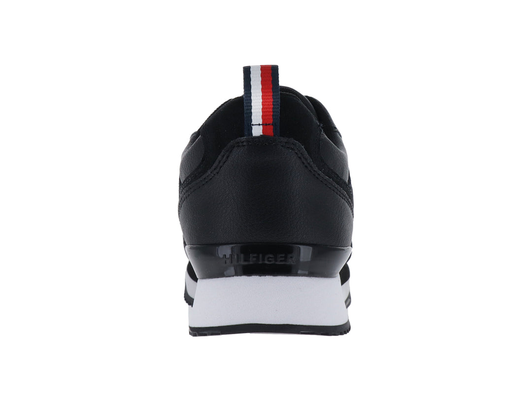 Tenis Tommy Hilfiger modelo Essential Runner en color negro con suela blanca y logo dorado lateral.