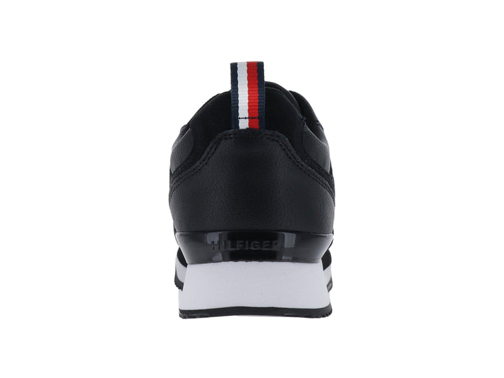 Tenis Tommy Hilfiger modelo Essential Runner en color negro con suela blanca y logo dorado lateral.