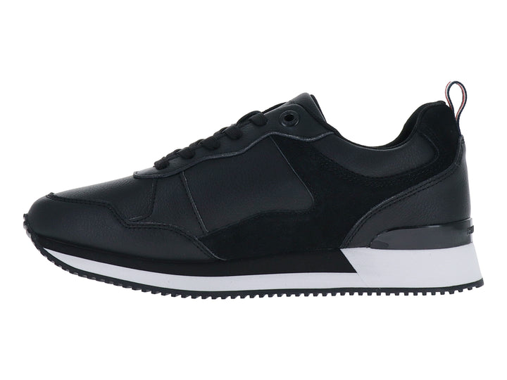 Tenis Tommy Hilfiger modelo Essential Runner en color negro con suela blanca y logo dorado lateral.