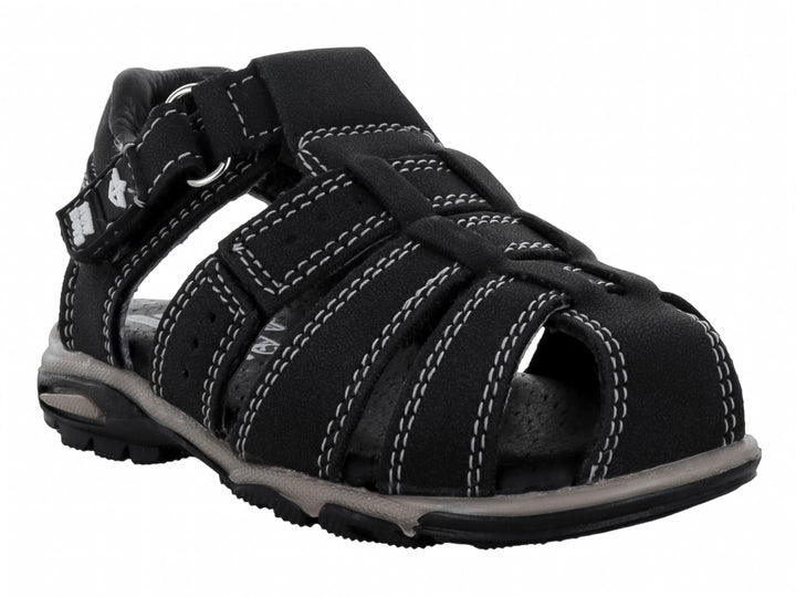Sandalias negras cerradas para niño con correas ajustables de velcro y suela gris.