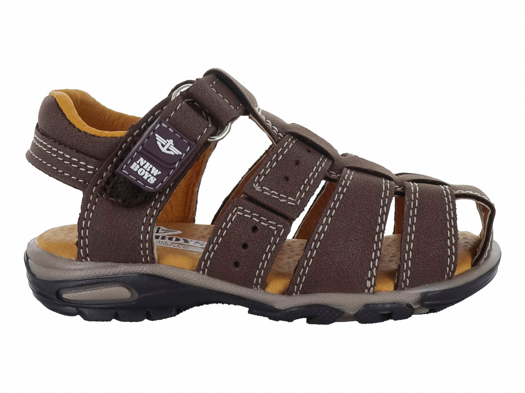 Sandalia infantil cerrada color marrón madera con correa ajustable y suela gris.