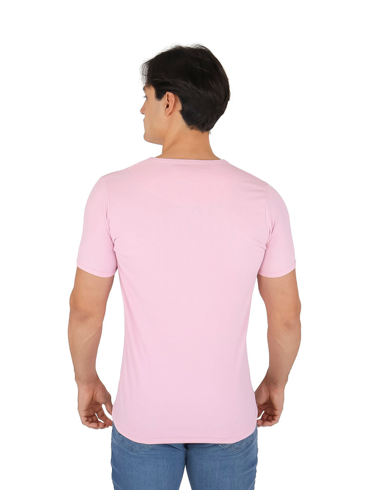 Hombre vistiendo una playera de manga corta en color rosa pastel con cuello redondo.
