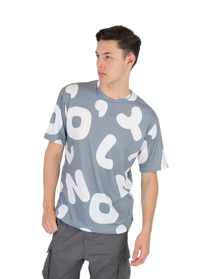 Hombre vistiendo playera de manga corta color plata con estampado abstracto en blanco.