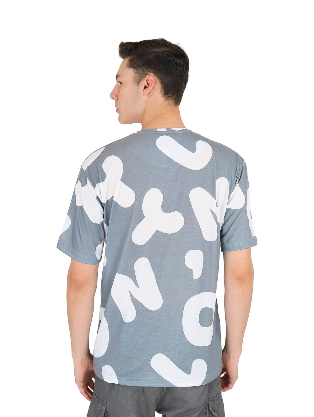 Hombre vistiendo playera de manga corta color plata con estampado abstracto en blanco.