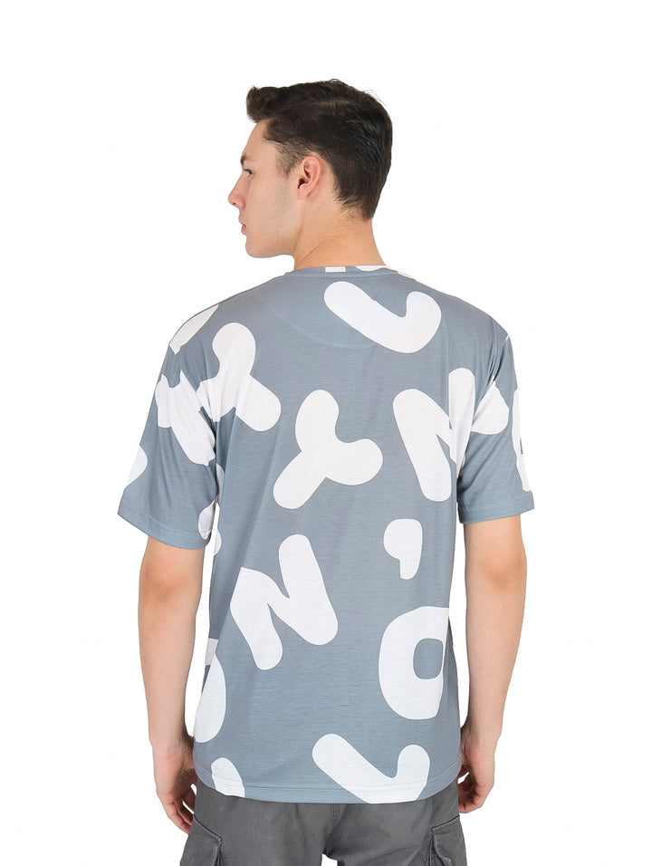 Hombre vistiendo playera de manga corta color plata con estampado abstracto en blanco.