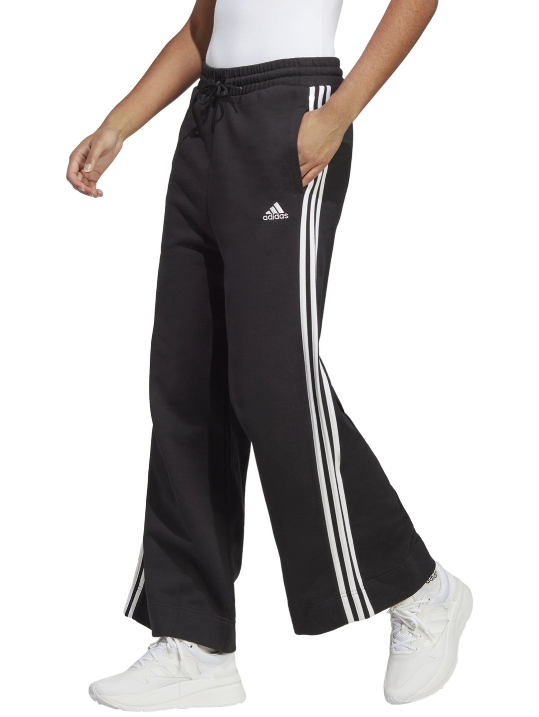 Pantalones deportivos Adidas de pierna ancha en color negro con tres franjas blancas laterales.