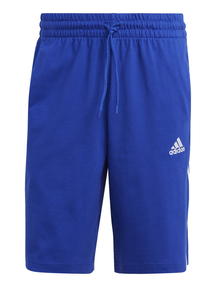 Hombre vistiendo shorts deportivos Adidas color azul con tres franjas blancas laterales.