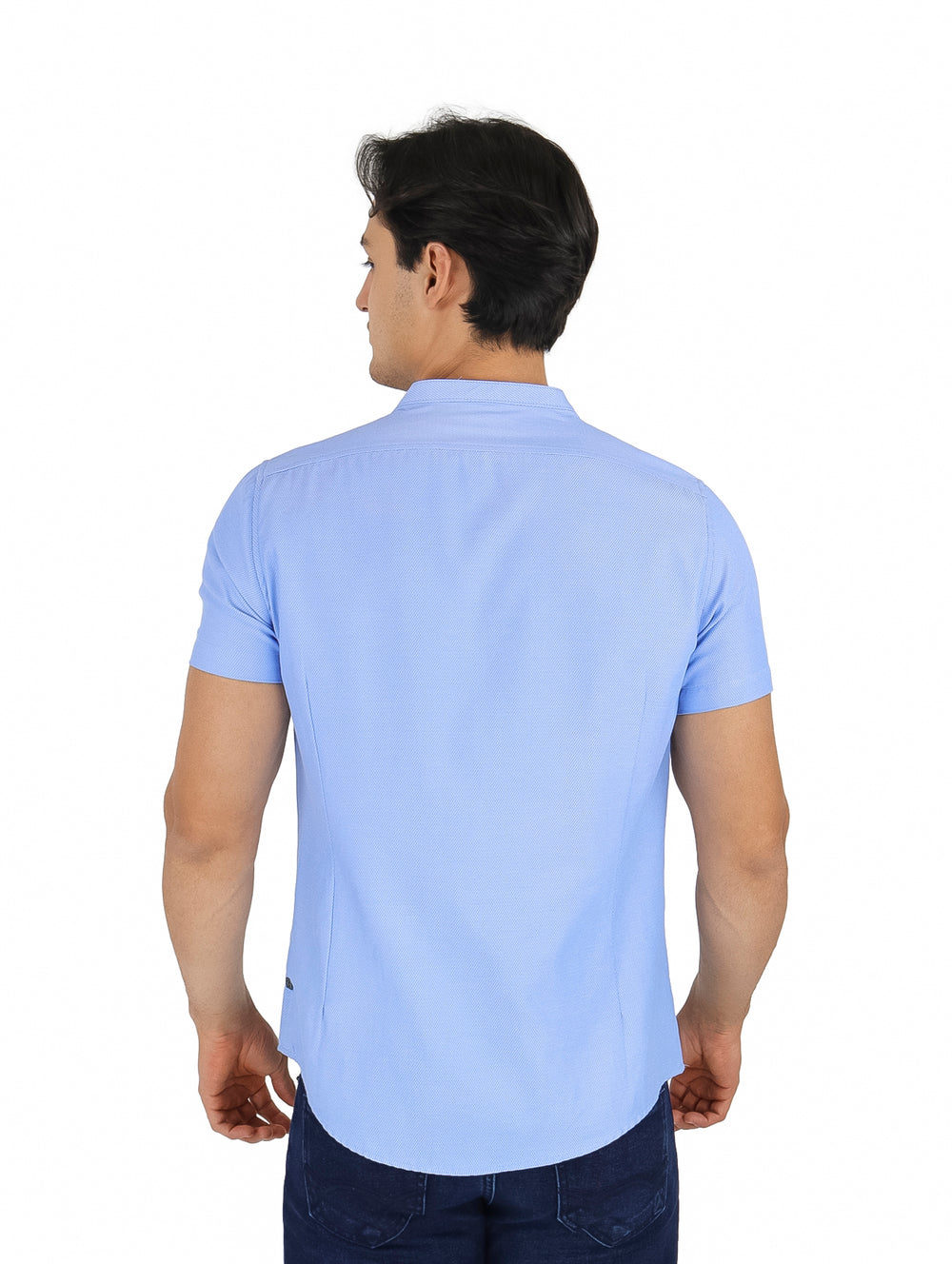 Hombre vistiendo camisa azul claro de manga corta con cuello henley y bolsillo frontal.