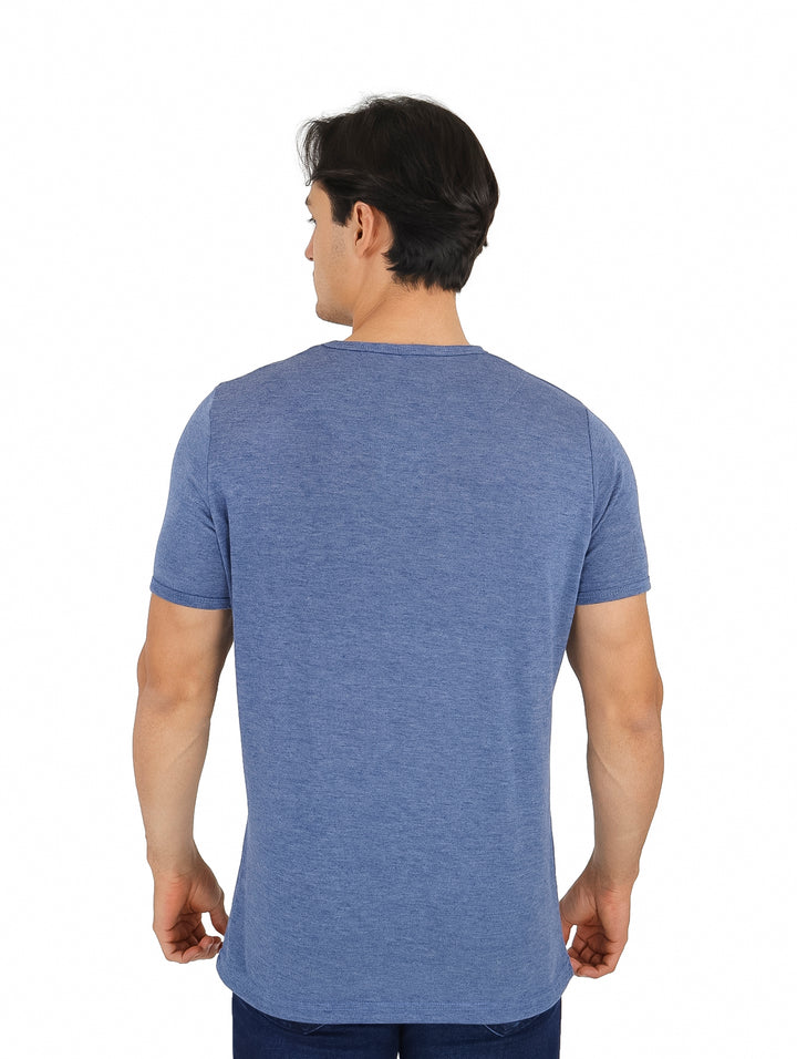 Hombre vistiendo una playera azul de manga corta y cuello redondo.