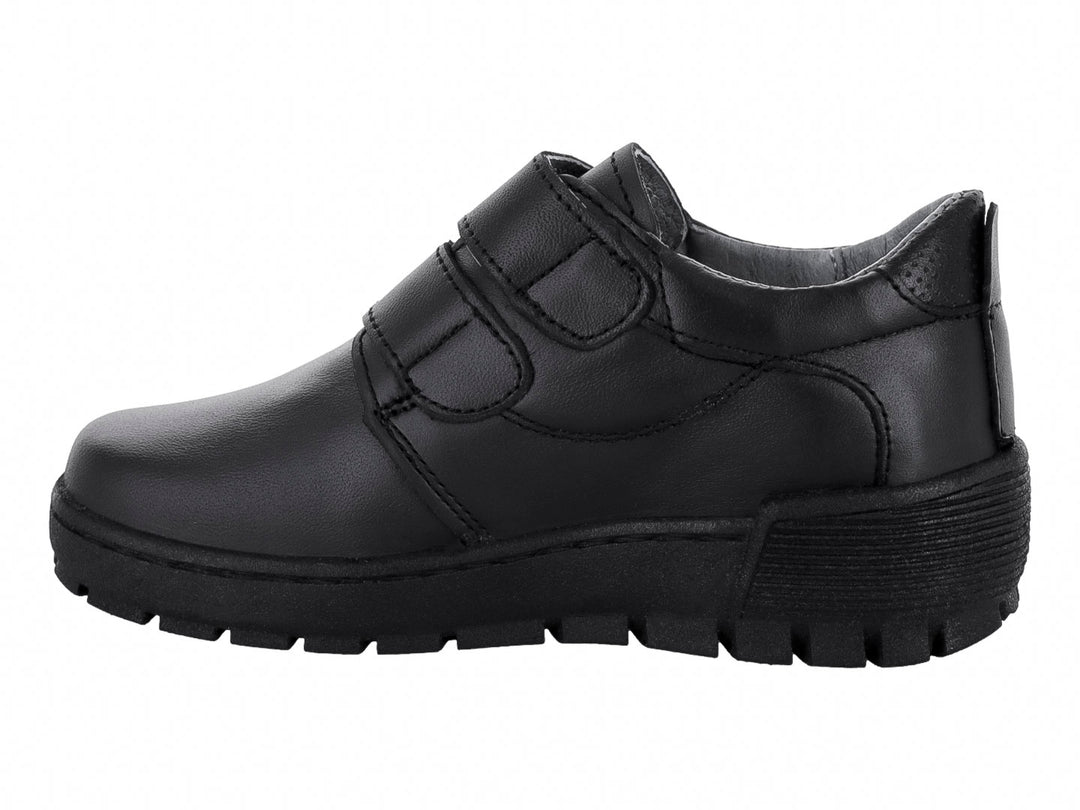 Zapato infantil color negro con cierre de velcro y suela gruesa.