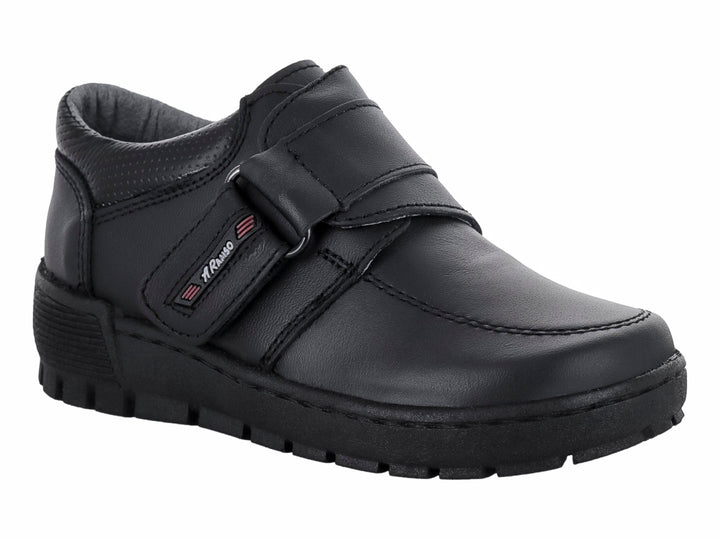 Zapato infantil color negro con cierre de velcro y suela gruesa.