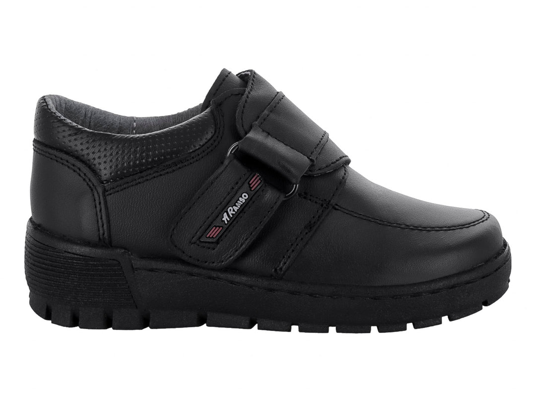 Zapato infantil color negro con cierre de velcro y suela resistente.