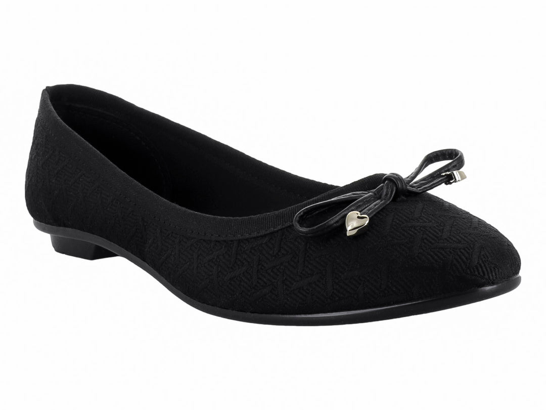 Zapato plano tipo ballerina color negro con textura geométrica y detalle de moño con corazón plateado.