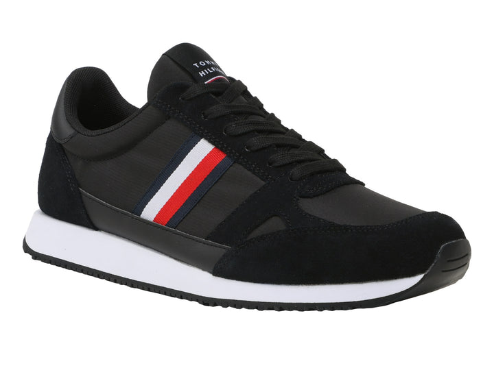 Tenis Tommy Hilfiger negros con suela blanca y detalle de franja roja, blanca y azul en el costado.