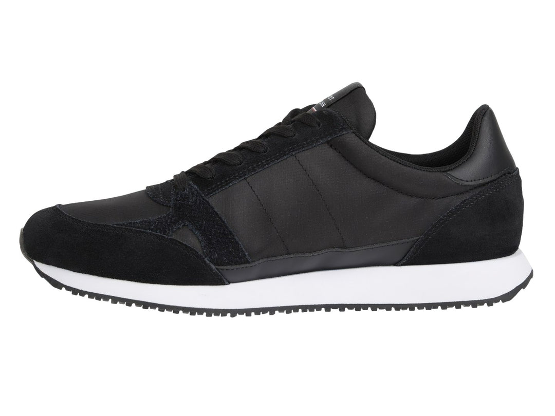 Tenis Tommy Hilfiger negros con suela blanca y detalle de franja roja, blanca y azul en el costado.