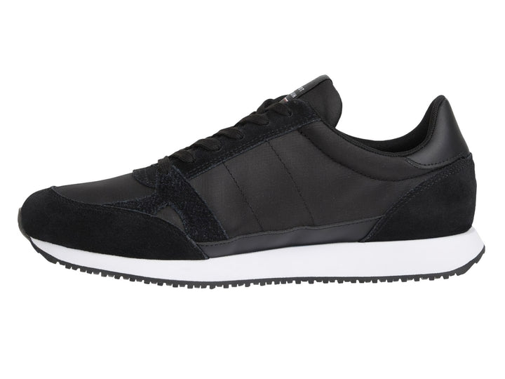 Tenis Tommy Hilfiger negros con suela blanca y detalle de franja roja, blanca y azul en el costado.