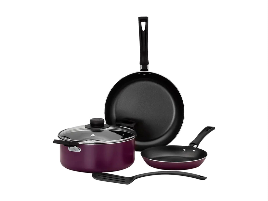 Batería de cocina Vasconia color violeta que incluye olla con tapa, dos sartenes y una espátula negra.