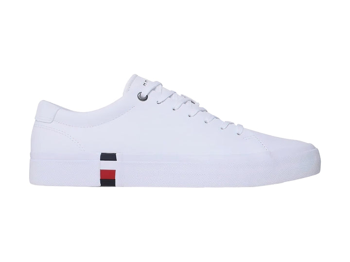 Tenis Tommy Hilfiger color blanco de cuero con detalle tricolor en la suela y agujetas blancas.