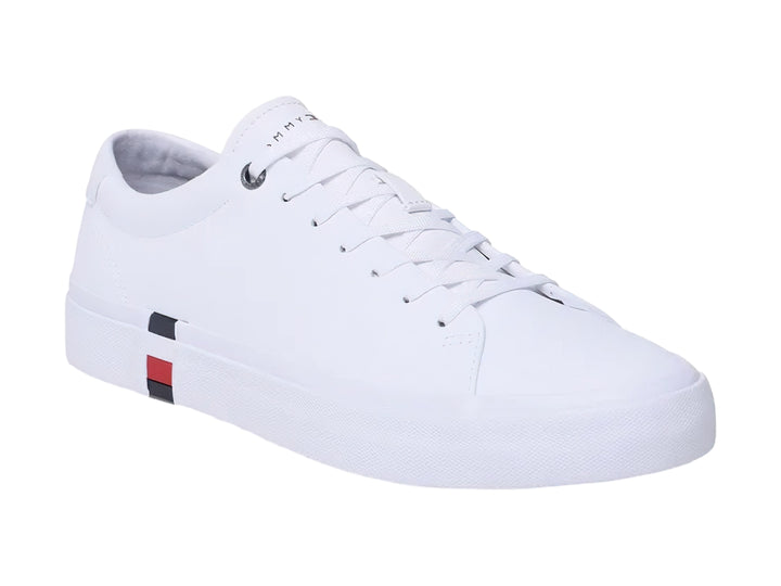 Tenis Tommy Hilfiger color blanco de cuero con detalle tricolor en la suela y agujetas blancas.