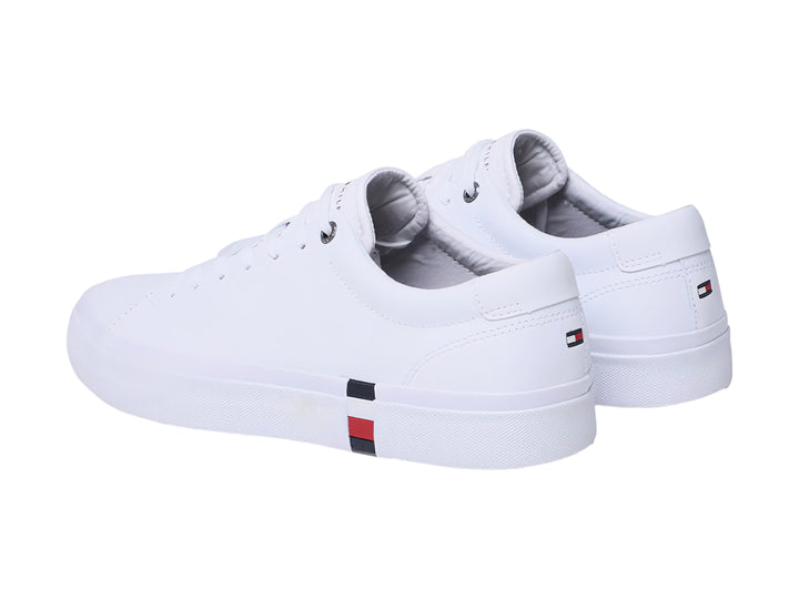 Tenis Tommy Hilfiger color blanco de cuero con detalle tricolor en la suela y agujetas blancas.