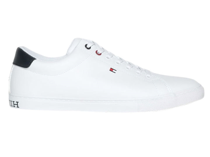Tenis casuales Tommy Hilfiger de color blanco con detalle en azul marino en el talón y suela blanca.