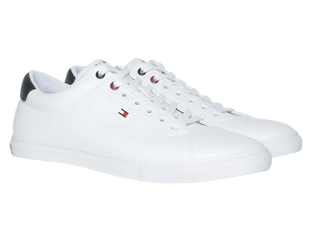 Tenis casuales Tommy Hilfiger de color blanco con detalle en azul marino en el talón y suela blanca.