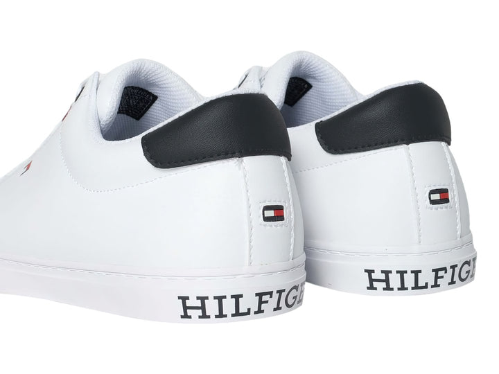Tenis casuales Tommy Hilfiger de color blanco con detalle en azul marino en el talón y suela blanca.
