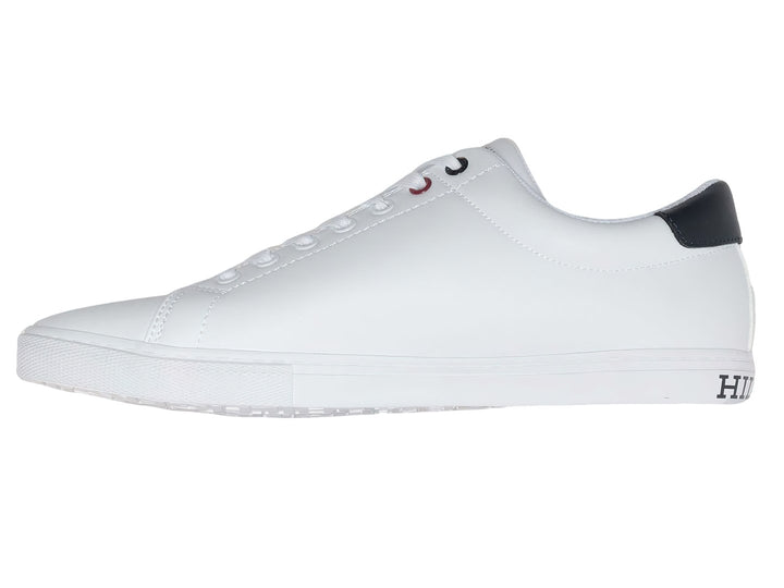 Tenis casuales Tommy Hilfiger de color blanco con detalle en azul marino en el talón y suela blanca.