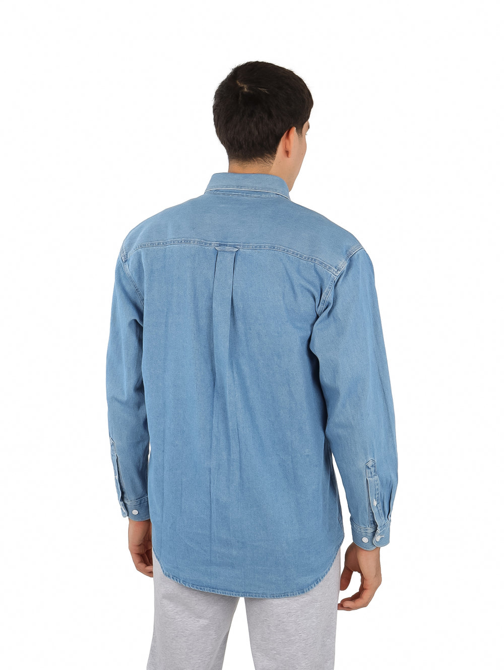 Hombre vistiendo una camisa casual de manga larga en color azul bleach con un bolsillo frontal.