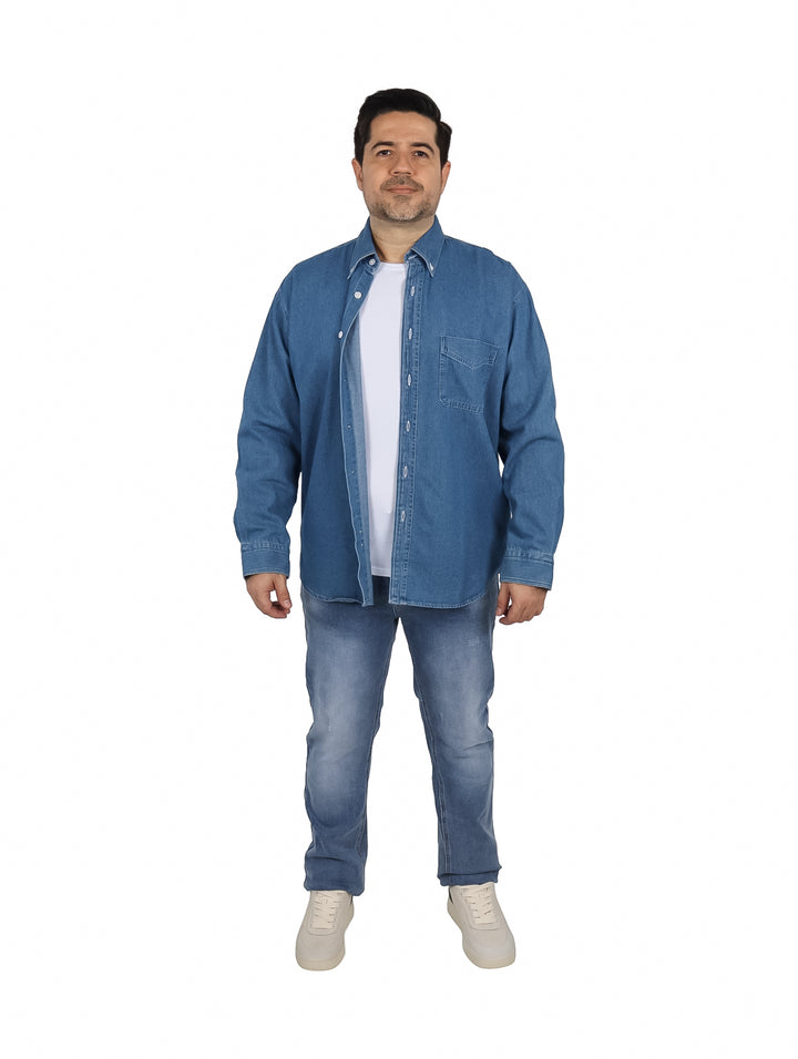Hombre vistiendo una camisa de mezclilla azul de manga larga con botones blancos y un bolsillo frontal.